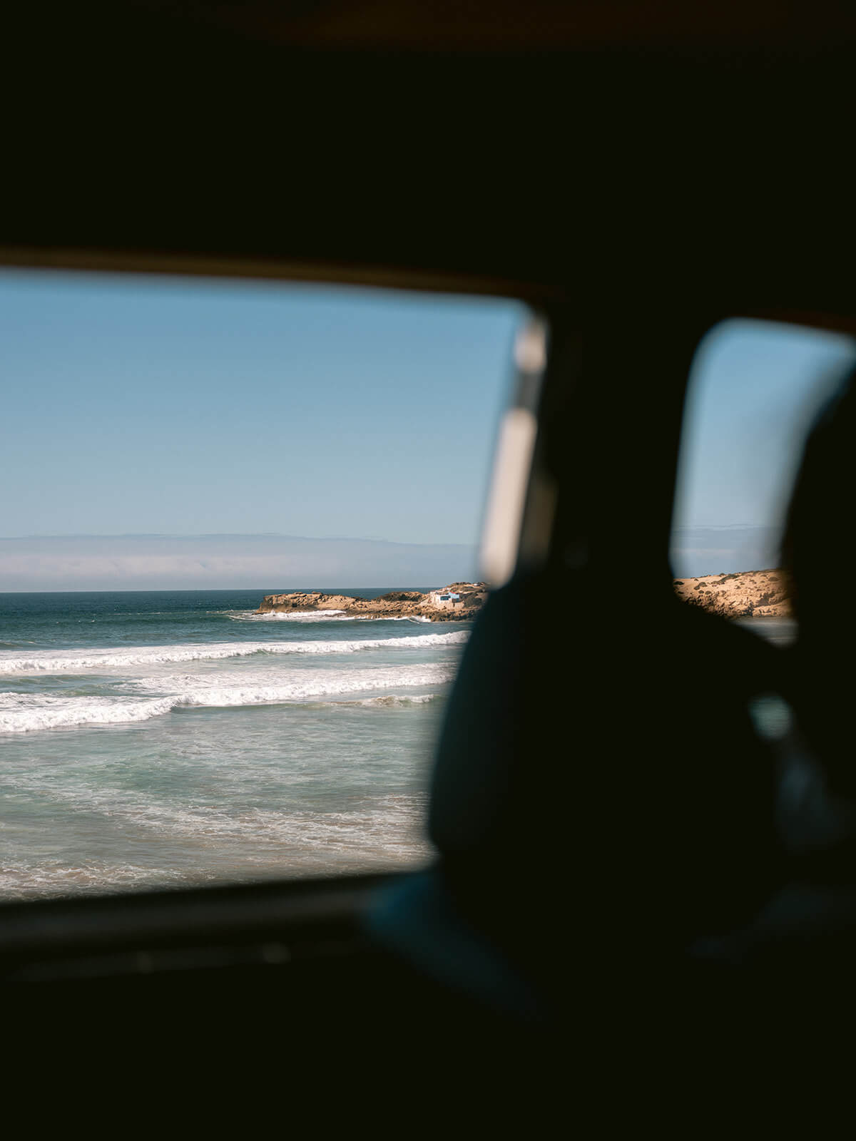 View at Imsouane bay - longest left wave of Africa, from the surf van | Colorful, adventurous travel photography by Raisa Zwart
